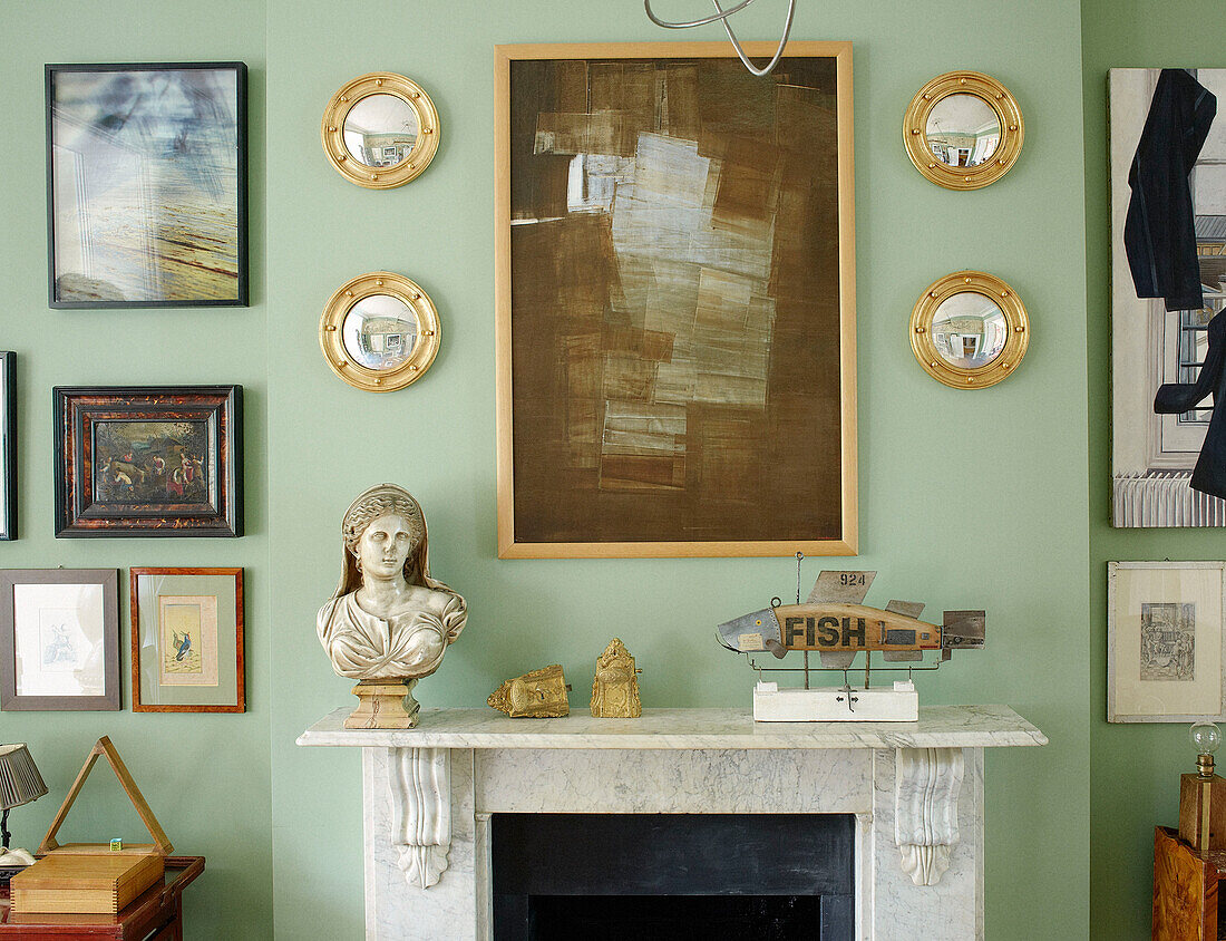 Konvexe Spiegel und Kunstwerk mit Büste über dem Kamin in einem Haus in Notting Hill, West London UK