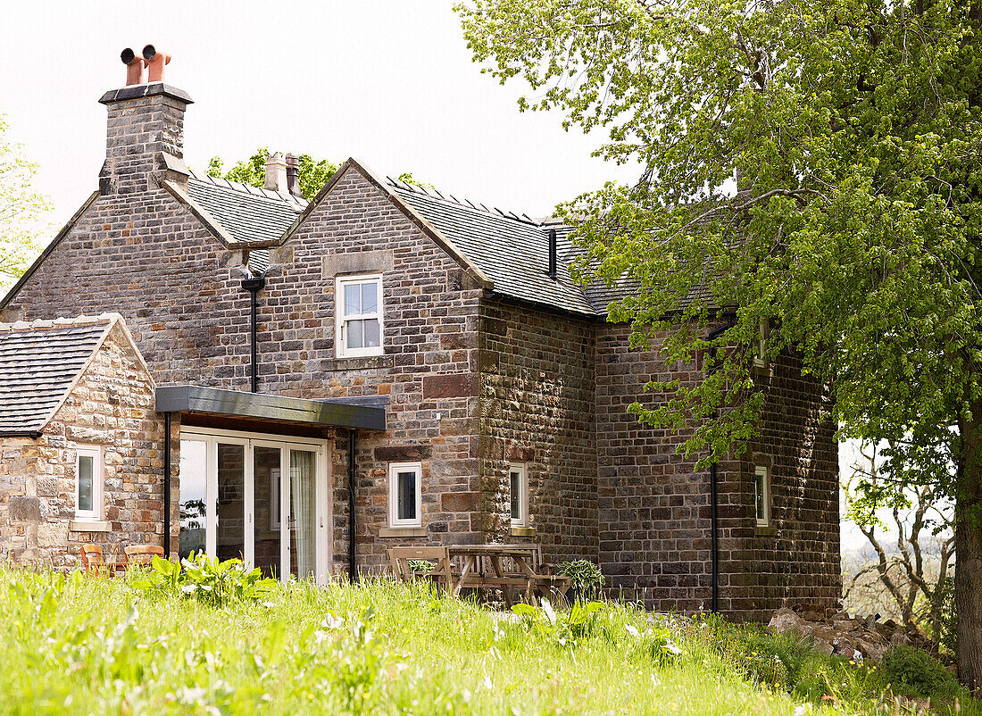 Stone farmhouse exterior set in grounds rural Derbyshire England UK