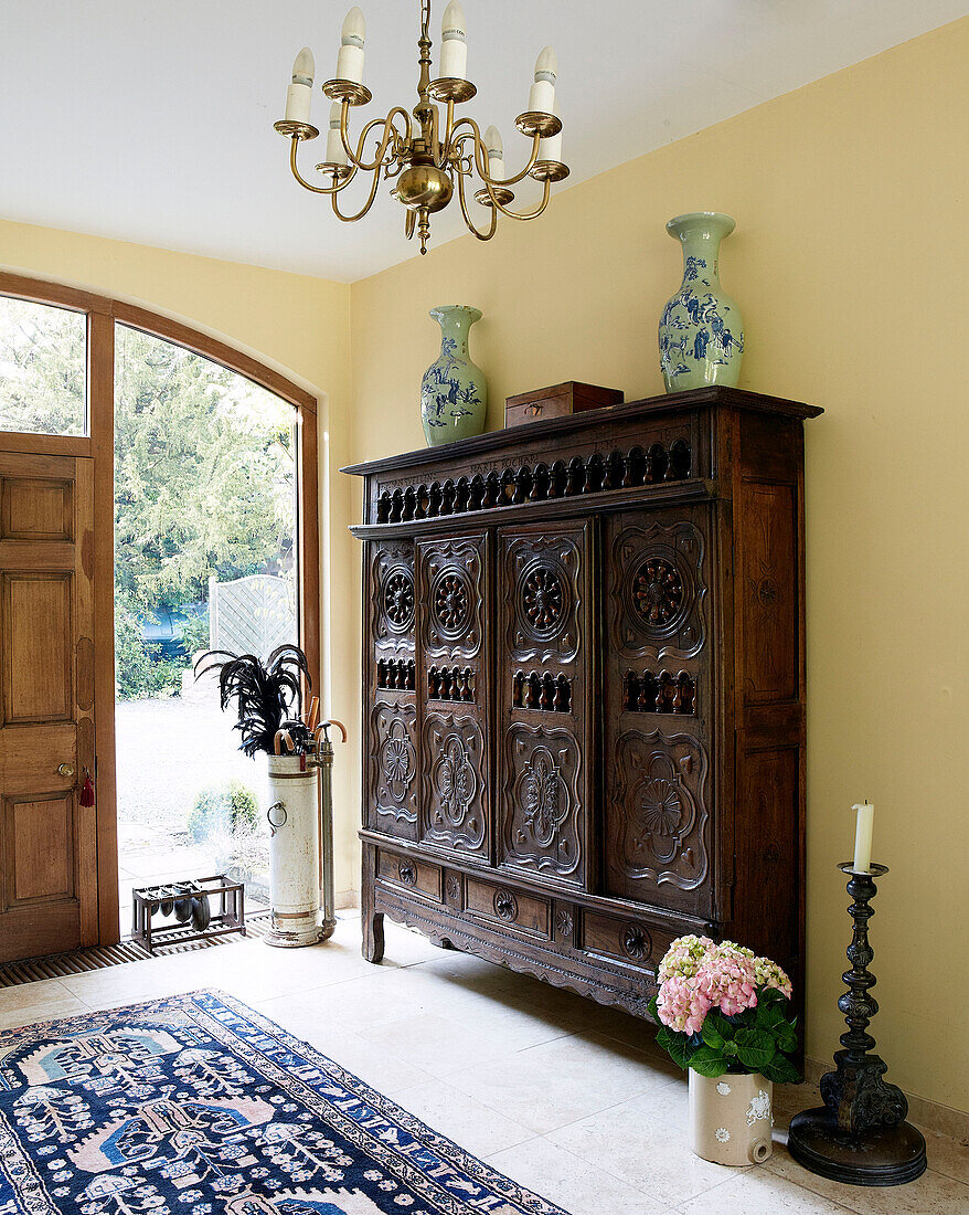 Carved wooden storage unit in entrance hall of traditional country house Welsh borders UK