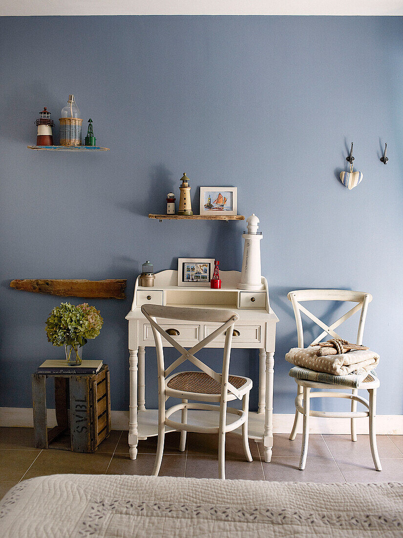 Cremefarbener Schreibtisch und Stuhl mit Kiste in einem hellblauen Schlafzimmer in einem Gästehaus in der Bretagne Frankreich