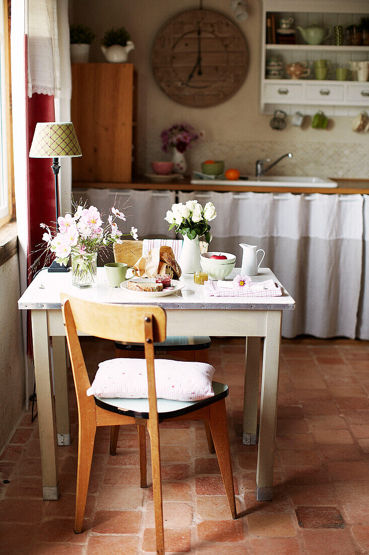Vintage-Stuhl am Frühstückstisch mit Schnittblumen in einem bretonischen Bauernhaus Frankreich