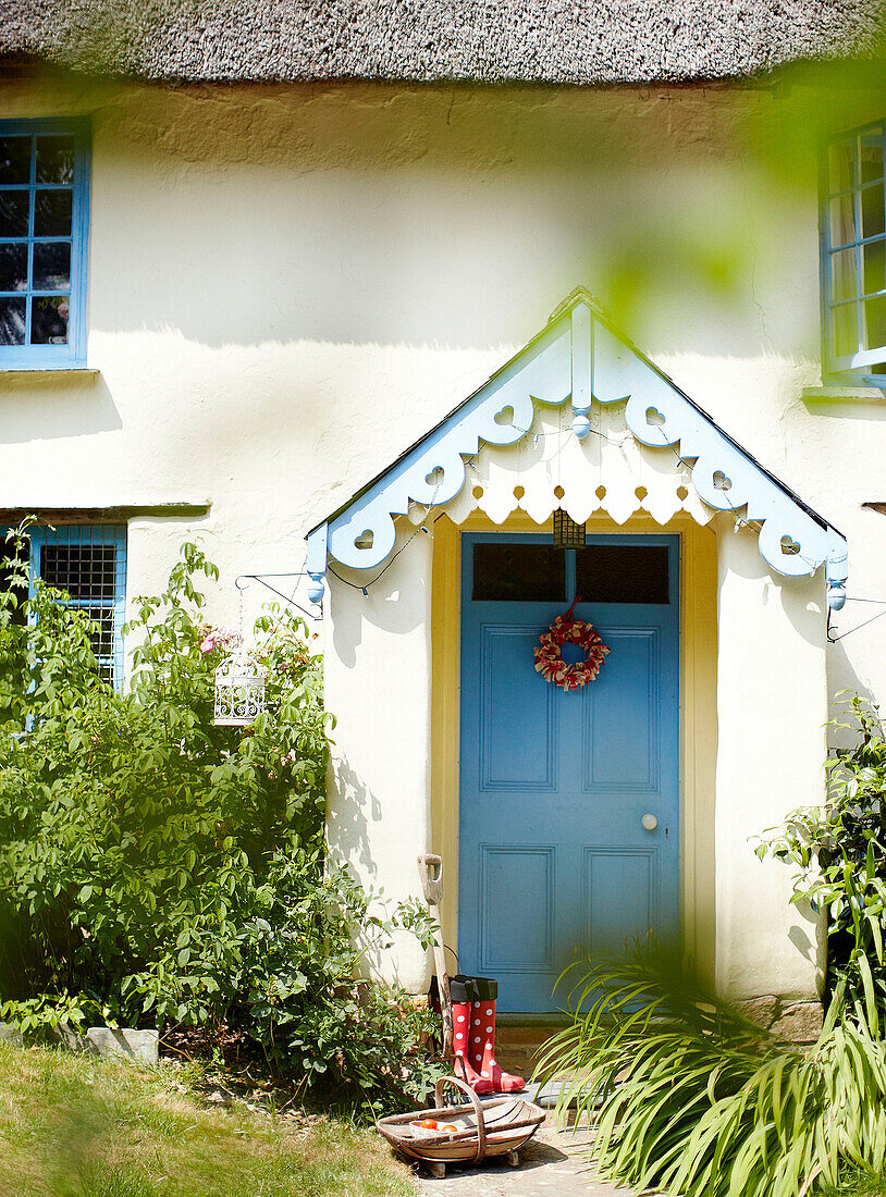 Blaue Haustür im Vorbau eines Ferienhauses in Devonshire, UK