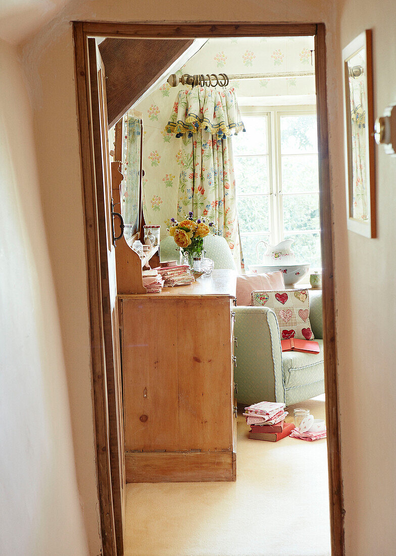 Blick durch den Türrahmen auf die Kommode im Wohnzimmer eines Cottages in Devonshire, UK