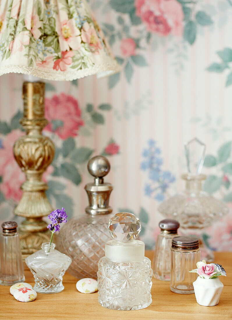 Verschiedene Parfümflaschen mit antiker Blumenlampe in einem Cottage in Devonshire UK
