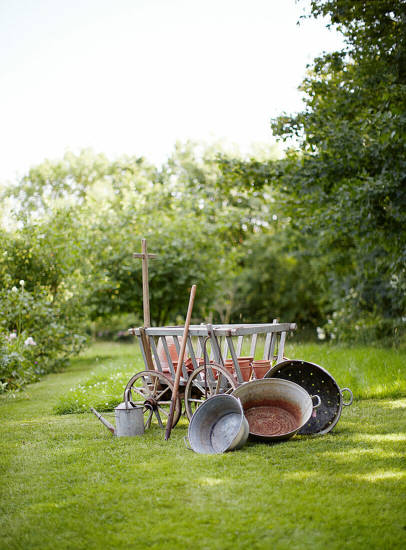 Garden with vintage galvanised buckets and old hay cart