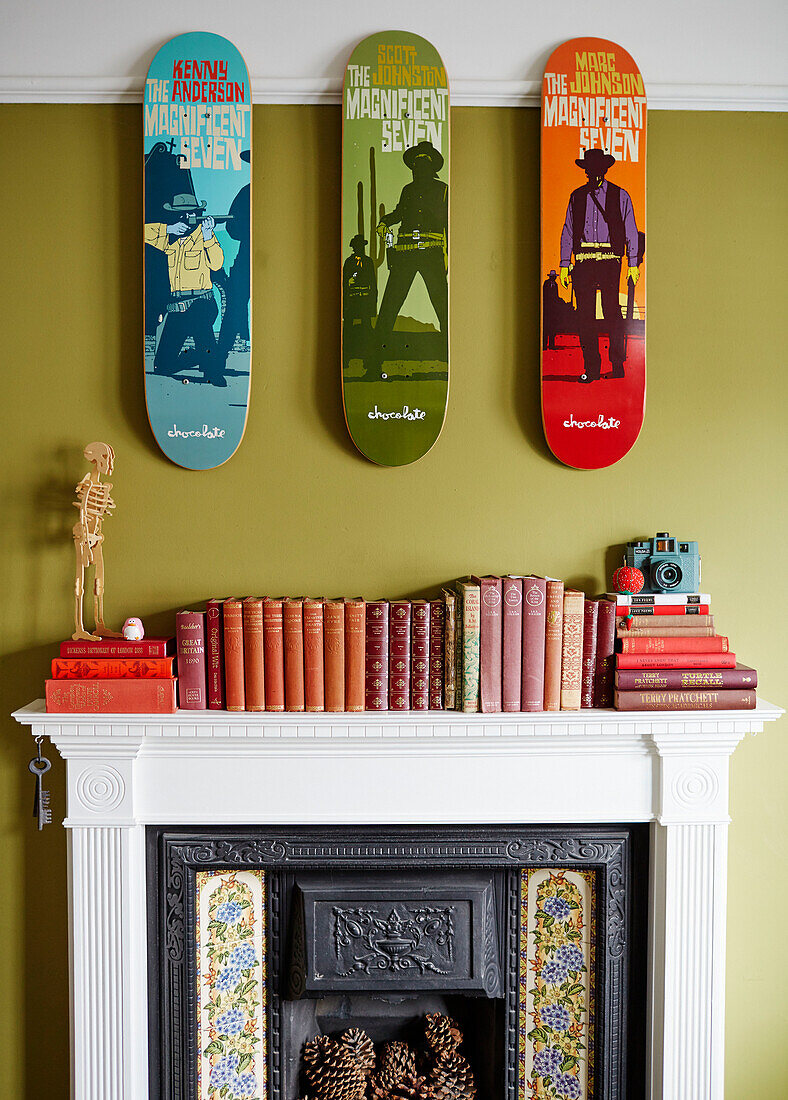Pop Art mit gebundenen Büchern über dem viktorianischen Kamin in einem Haus in Kent, England, UK