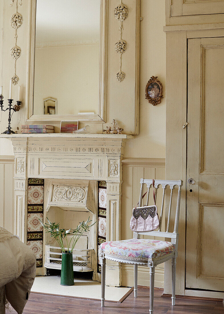 Cream mirror and fireplace with handbag on chair on Whitley Bay cottage Tyne and Wear England UK