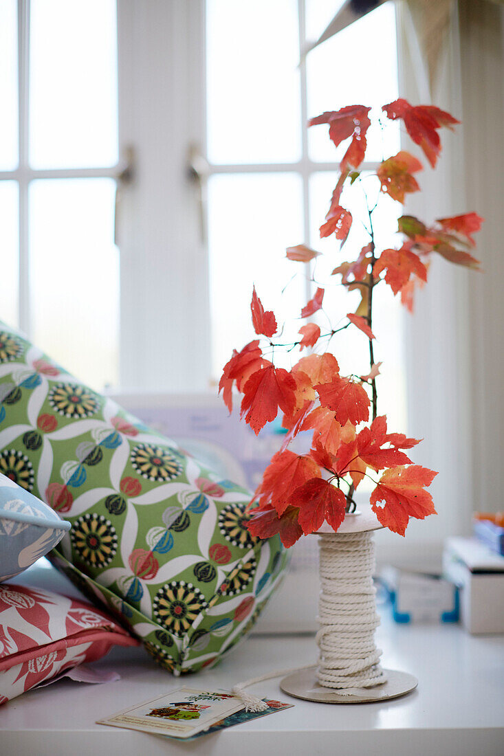 Autumn leaves with a reel of string and fabric bolster in Northumbrian textiles studio England UK