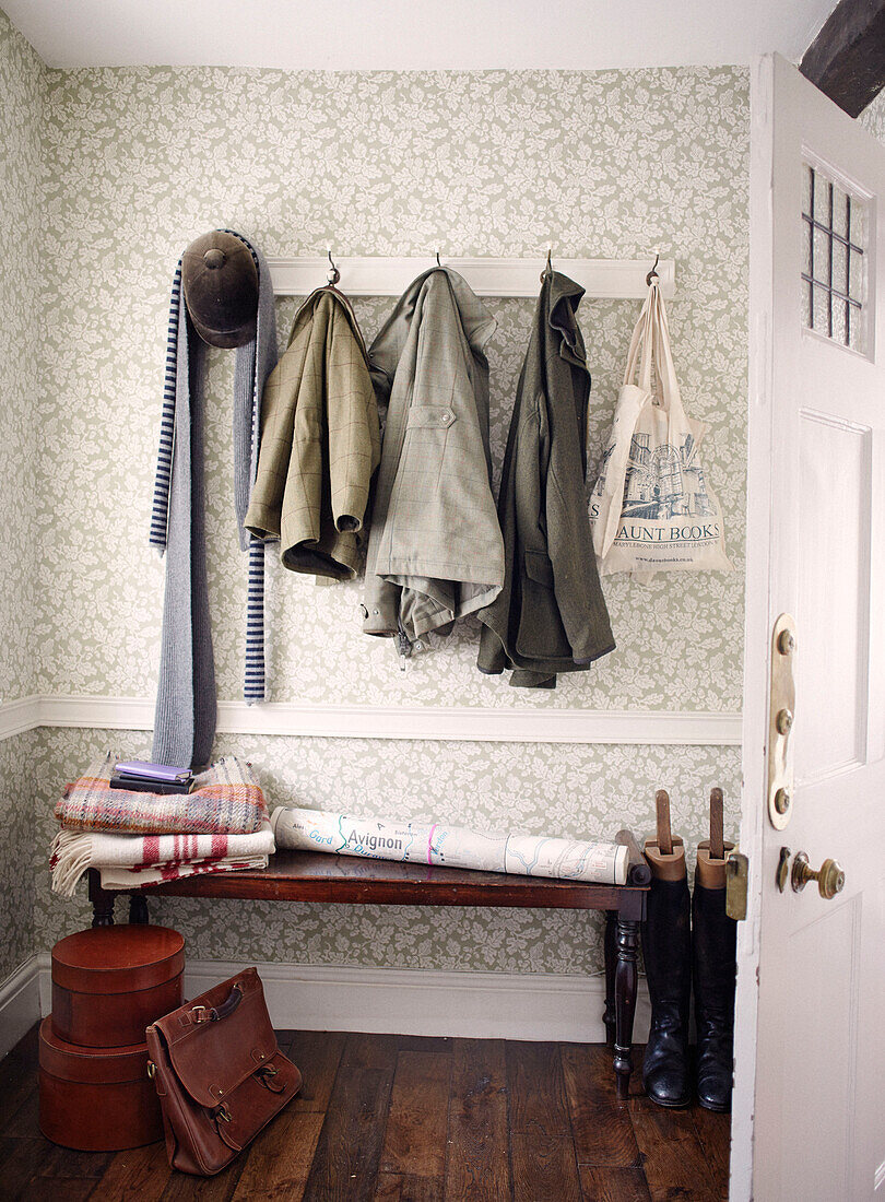 Tweed-Mäntel hängen mit Reitstiefeln und Hut in Bicester Garderobe Oxfordshire England