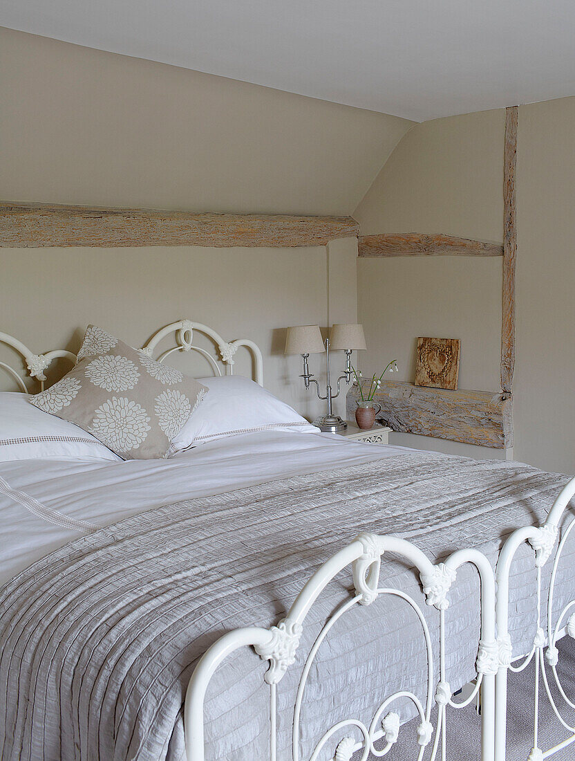 Cream quilt on double bed with metal footboard in Buckinghamshire home UK