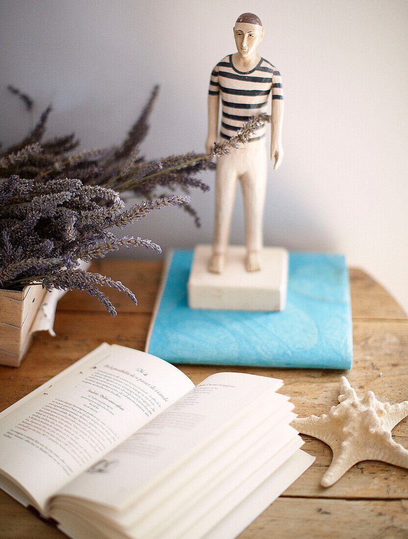 Open book and lavender with figurine of Frenchman in Brittany guesthouse France