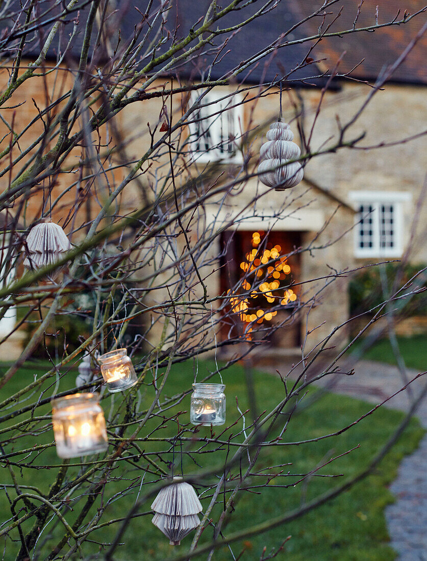 Tealights on branches in Oxfordshire garden England UK