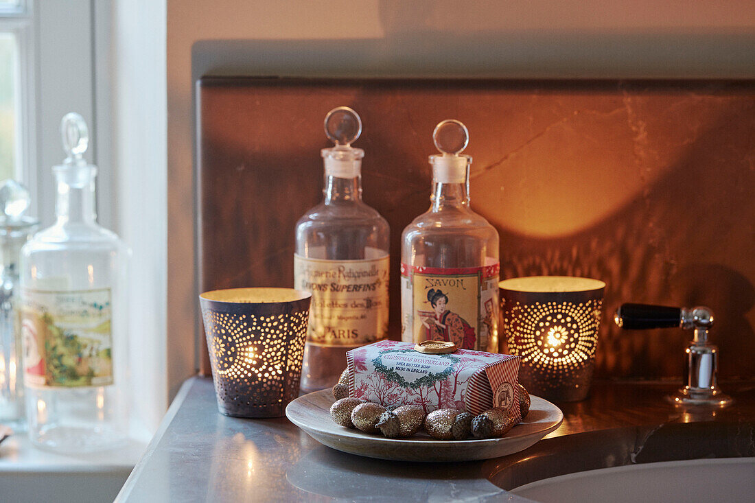 Orientalische Toilettenartikel und brennende Kerzen mit Seife in einem Badezimmer in Oxfordshire, England