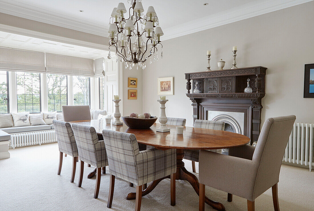 Esszimmerstühle am Tisch mit geschnitztem Holzkamin in einem Landhaus in Northumbria UK