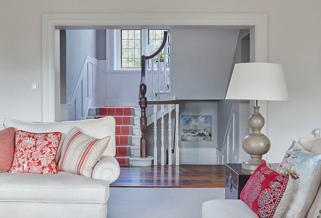 Cushions on seating in open plan living room with staircase access in Northumbrian country house UK