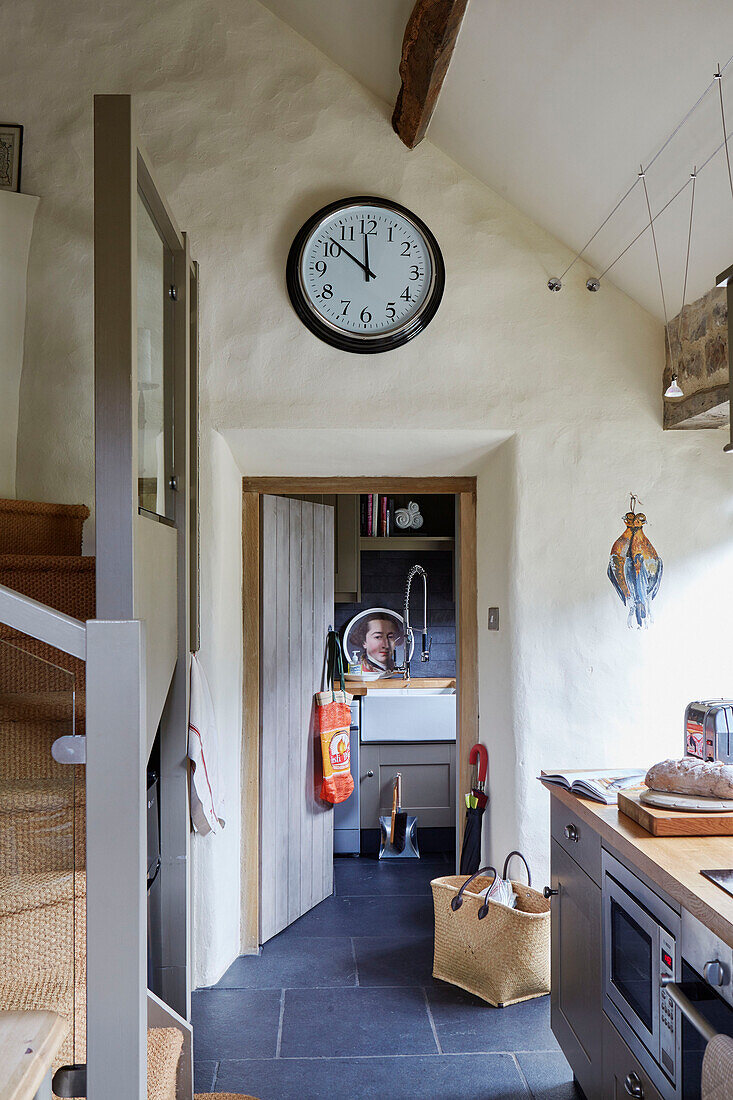 Large clock above kitchen doorway in Grade II listed Tudor bastle or fortified farmhouse Northumberland UK