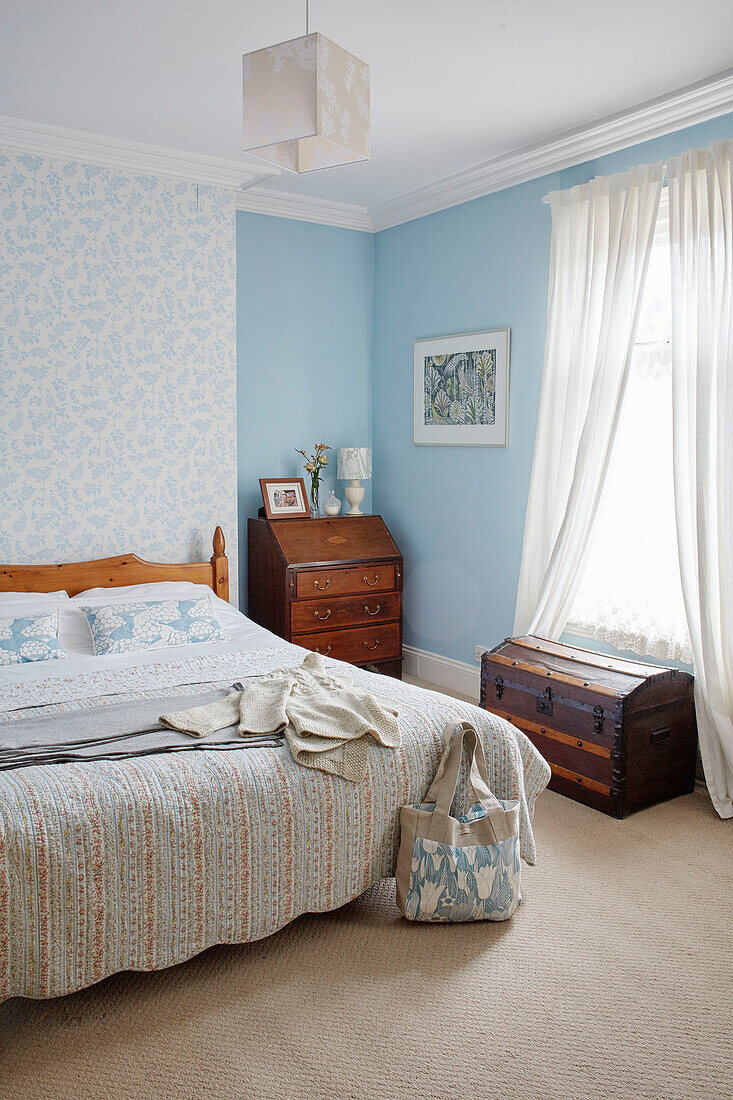 Vintage-Holzmöbel im hellblauen, sonnendurchfluteten Schlafzimmer eines Hauses in Birmingham England UK