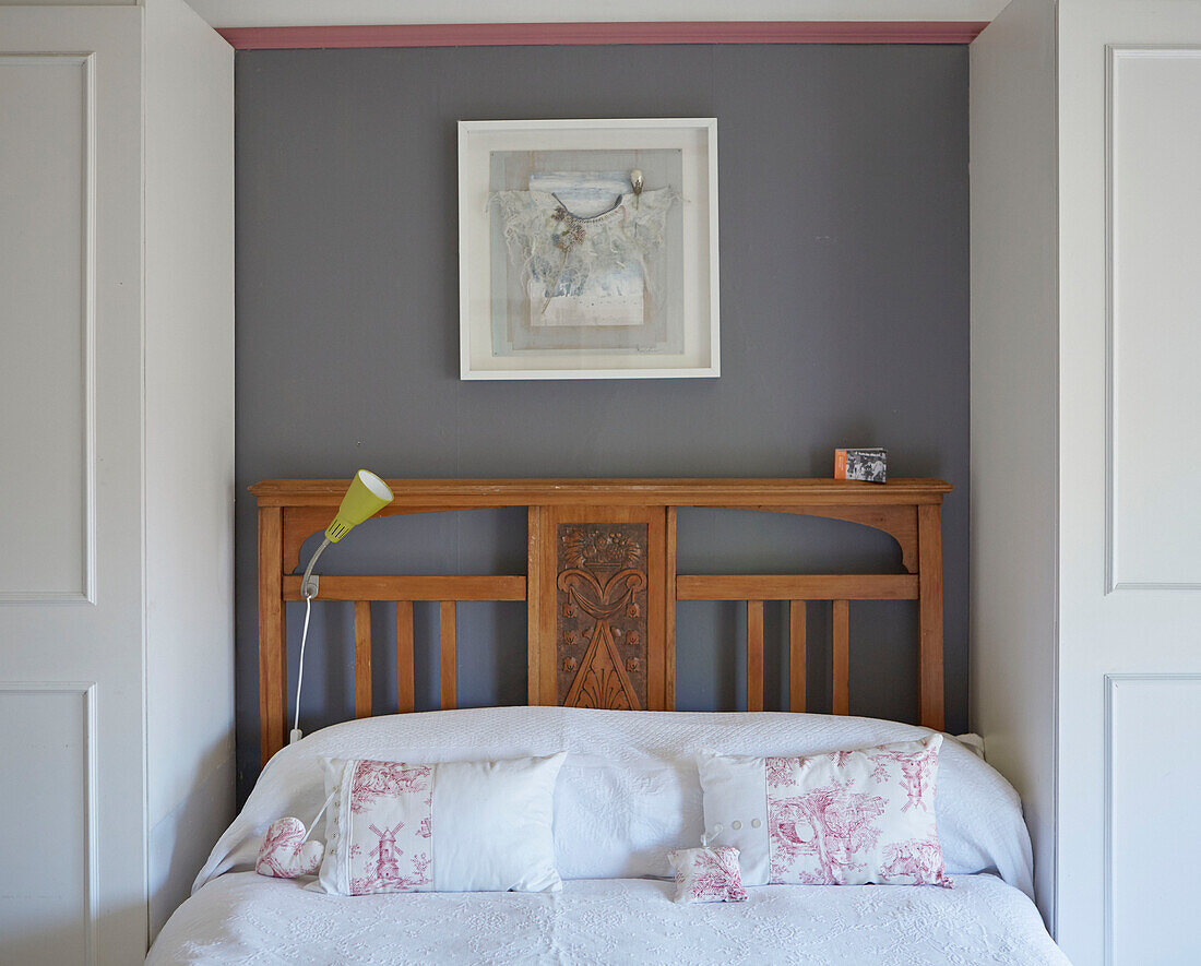 Framed artwork above carved wooden bed in Country Durham home, North East England