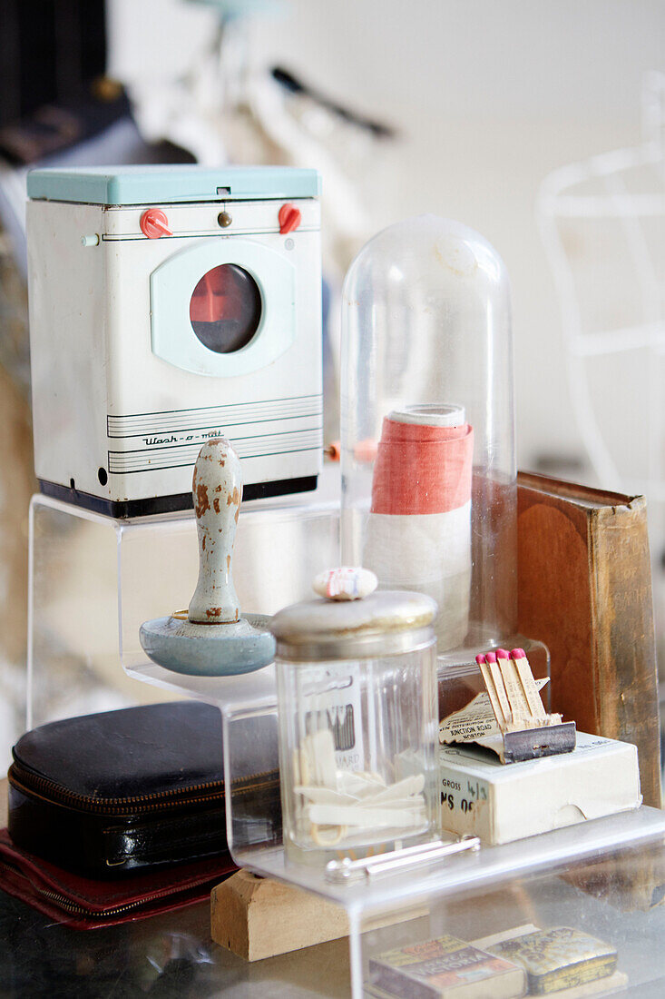 Retro-Waschmaschine und verschiedene Vintage-Objekte auf Plexiglasständer in einem Landhaus in Durham, Nordostengland