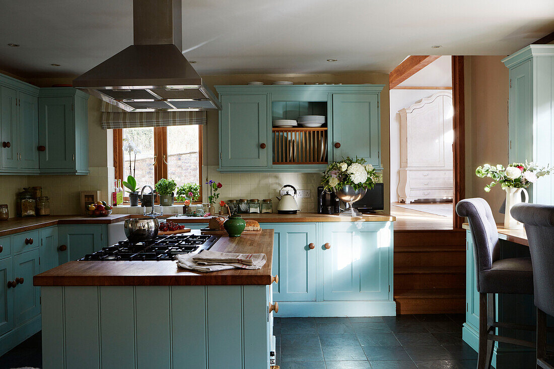 Gaskochfeld und Dunstabzug in hellblauer Einbauküche mit hellblauen Schränken in einem Haus in Kent, England, UK