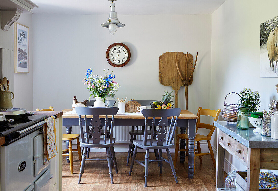 Landwirtschaftliche Geräte und Küchentisch mit bemalten Stühlen in einem Cottage in Northumberland, Tyne and Wear, England, UK