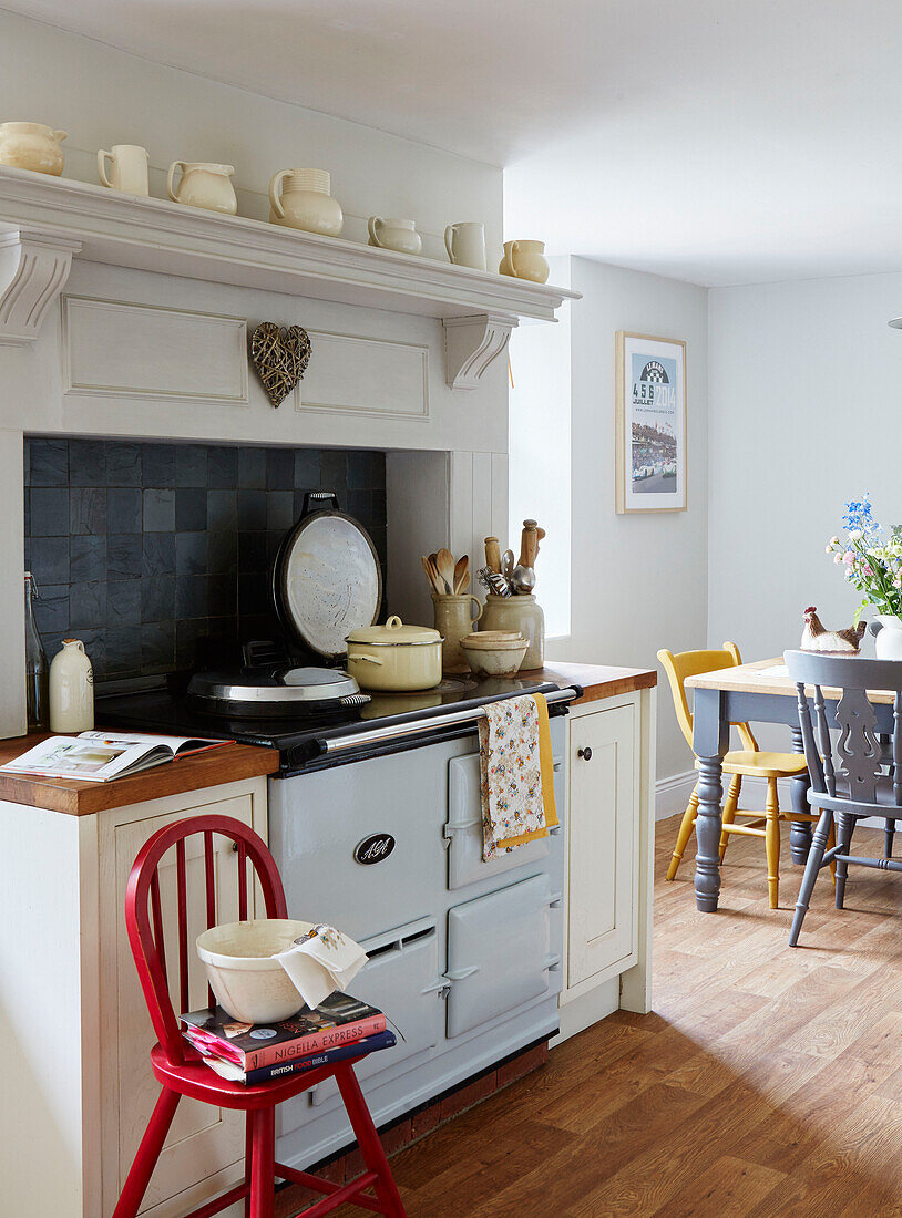 Saucepan on oven with painted chairs in Northumberland kitchen, Tyne and Wear, England, UK