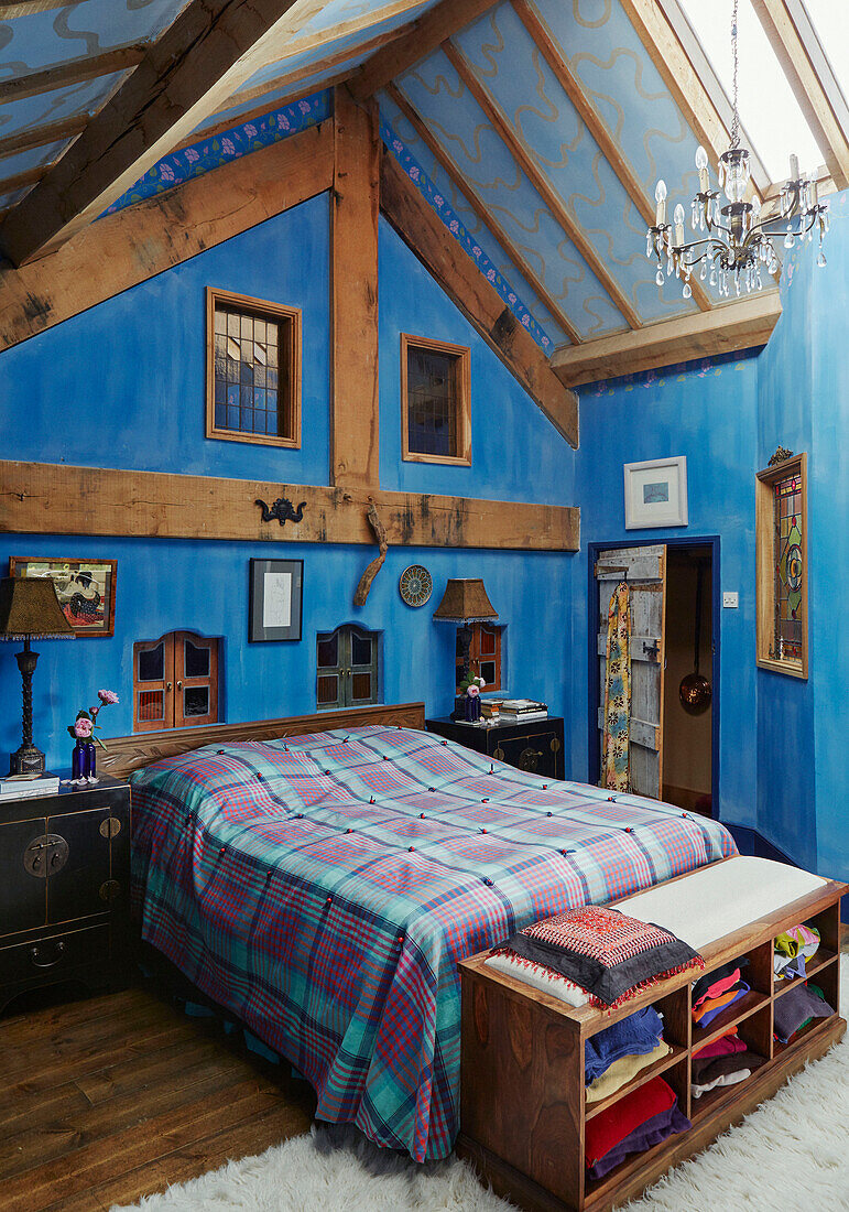 Doppelbett in einem blauen Schlafzimmer mit Holzrahmen in einem Bauernhaus in Herefordshire, UK