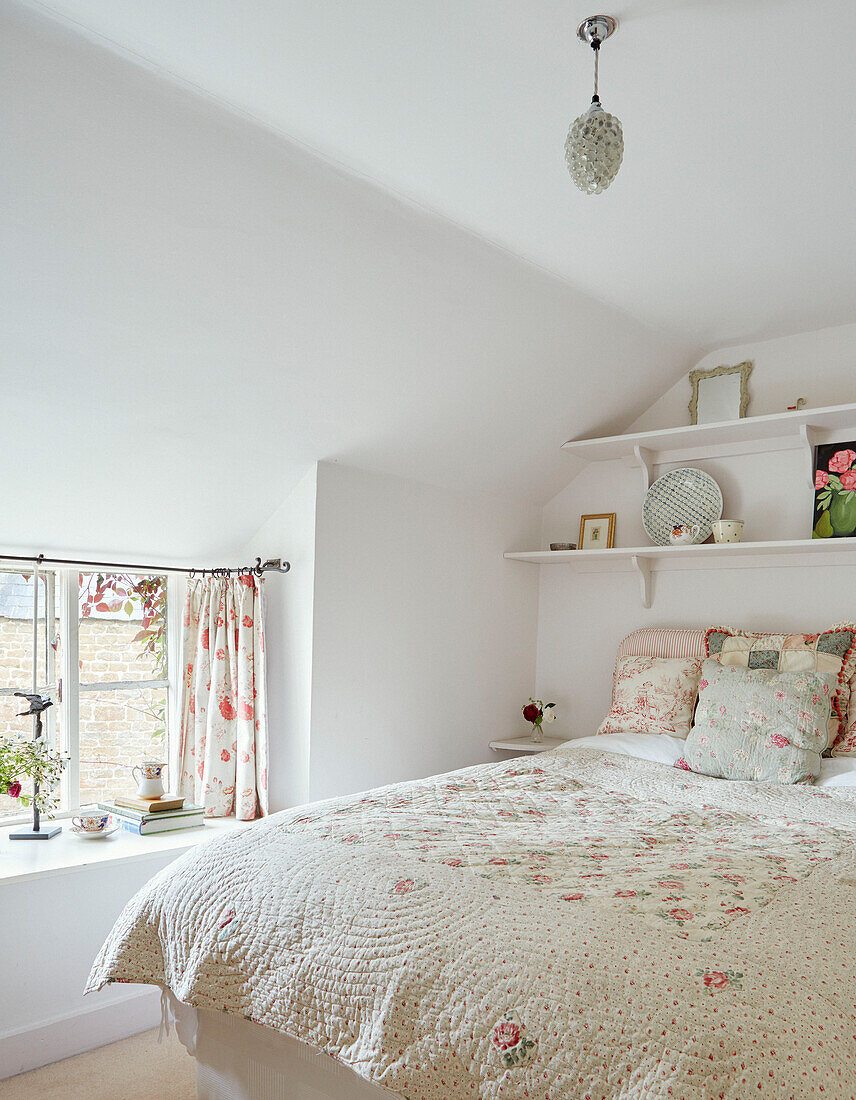 Gesteppter Bettbezug auf einem Doppelbett am Fenster in einem Cottage in Oxfordshire, UK