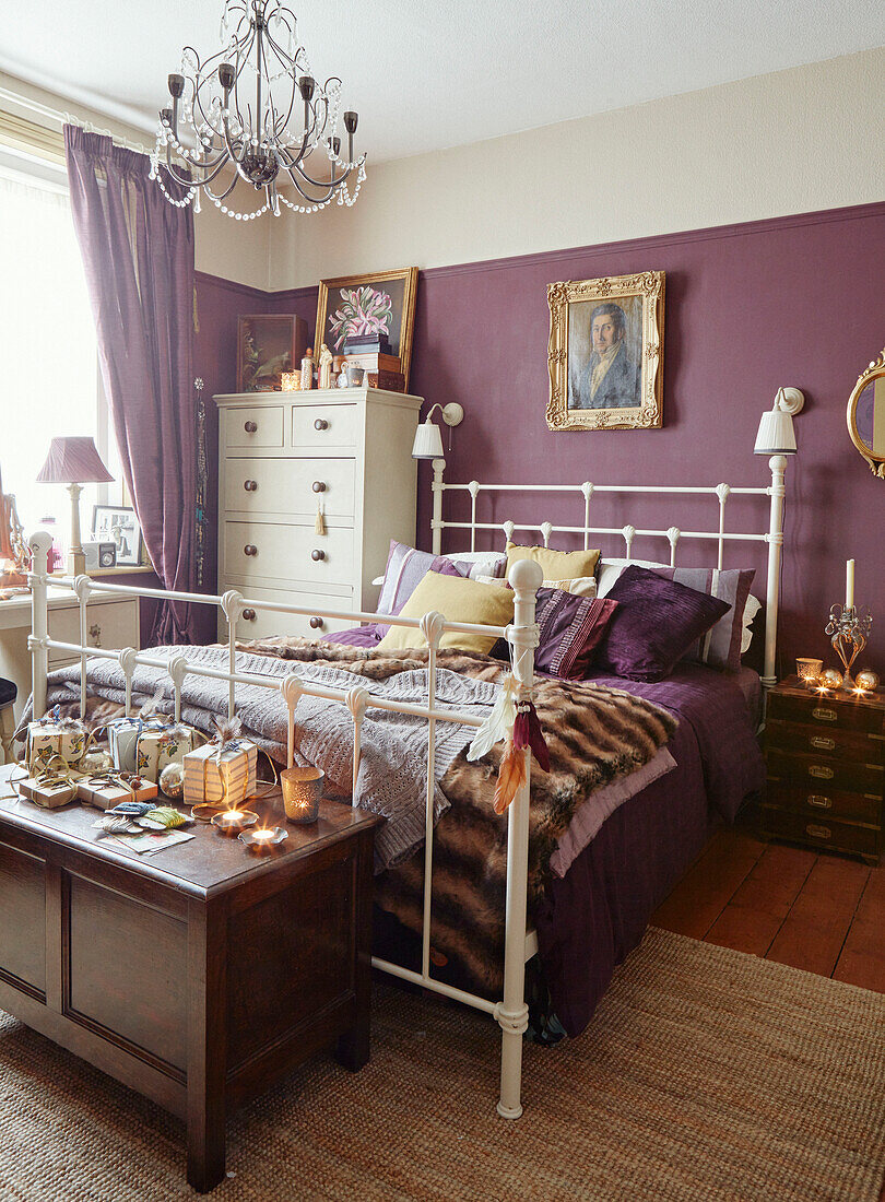 Bett mit weißem Metallrahmen in einem lila Schlafzimmer in Chippenham, Wiltshire, UK