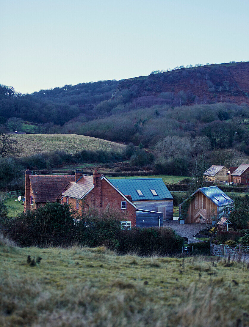 Ländliches Bauernhaus auf einem Hügel im Winter in Worcestershire, England, UK