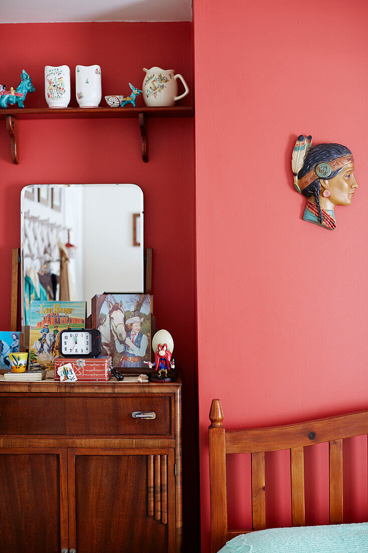 Neuartige Ornamente auf Retro-Möbeln in einem roten Schlafzimmer in einem Haus in der Grafschaft Durham, Nordostengland, UK