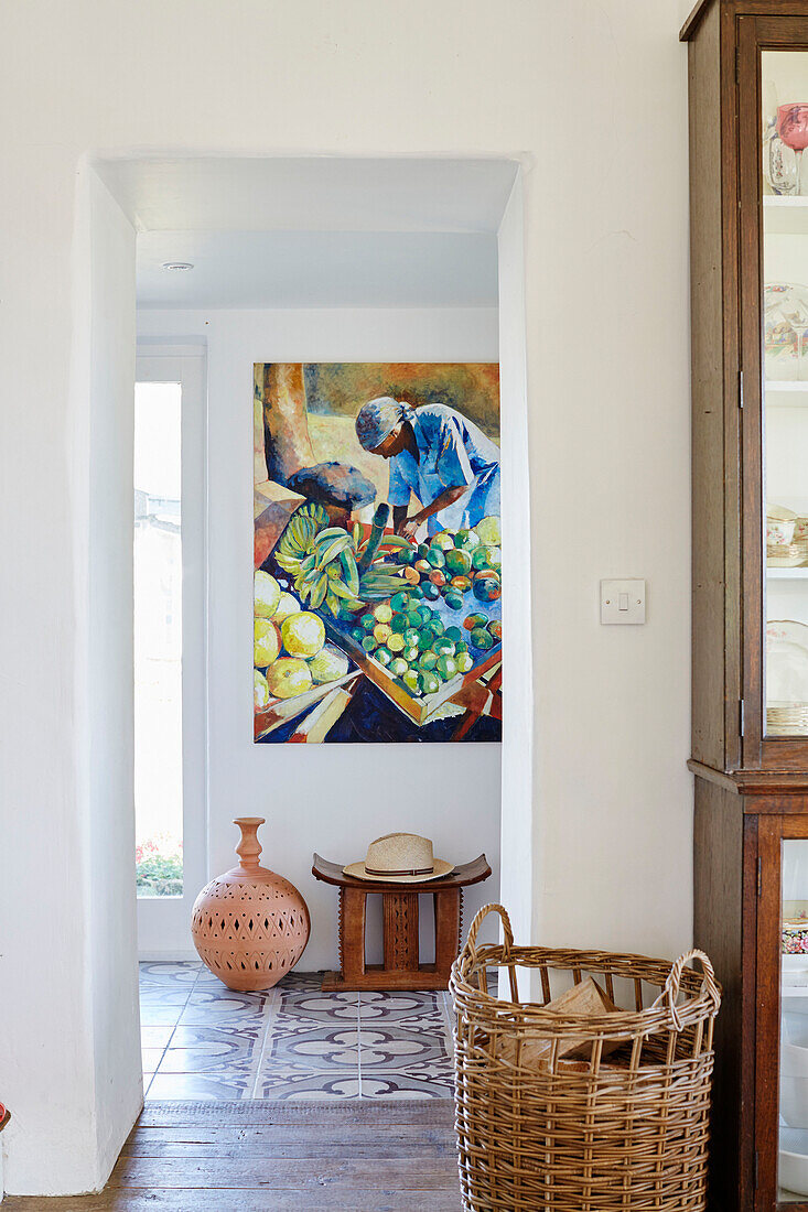 Log basket and modern artwork with stool and pottery lamp base in hallway of Yorkshire home, England, UK