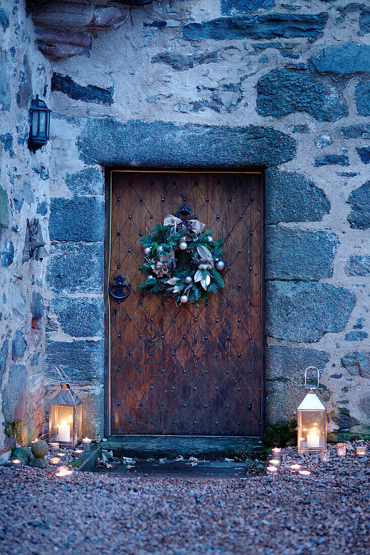 Beleuchtete Laternen an der alten hölzernen Eingangstür eines schottischen Schlosses, UK