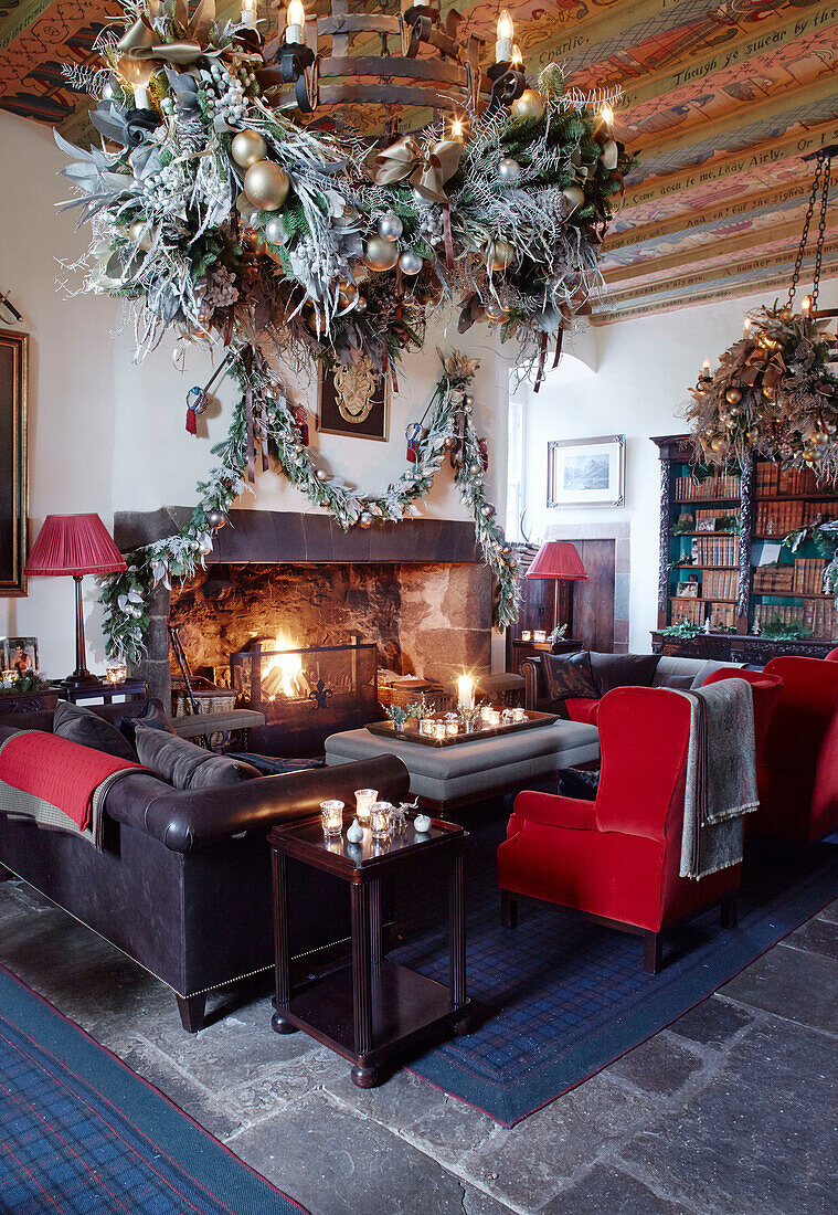 Weihnachtsgirlanden im Wohnzimmer mit beleuchtetem Feuer in einem schottischen Schloss, UK