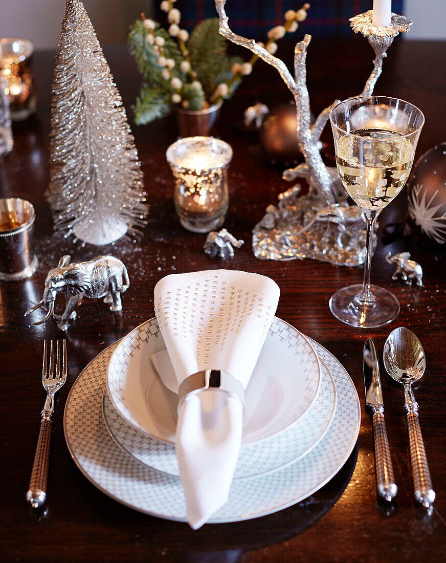 Napkin on place setting with glass of white wine on dining table in Scottish castle, UK