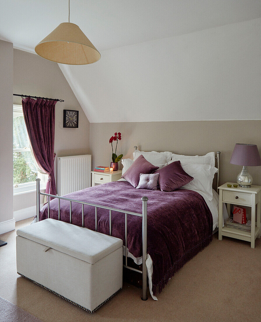 Lila Decke und passende Vorhänge mit Metallrahmenbett in einem britischen Haus