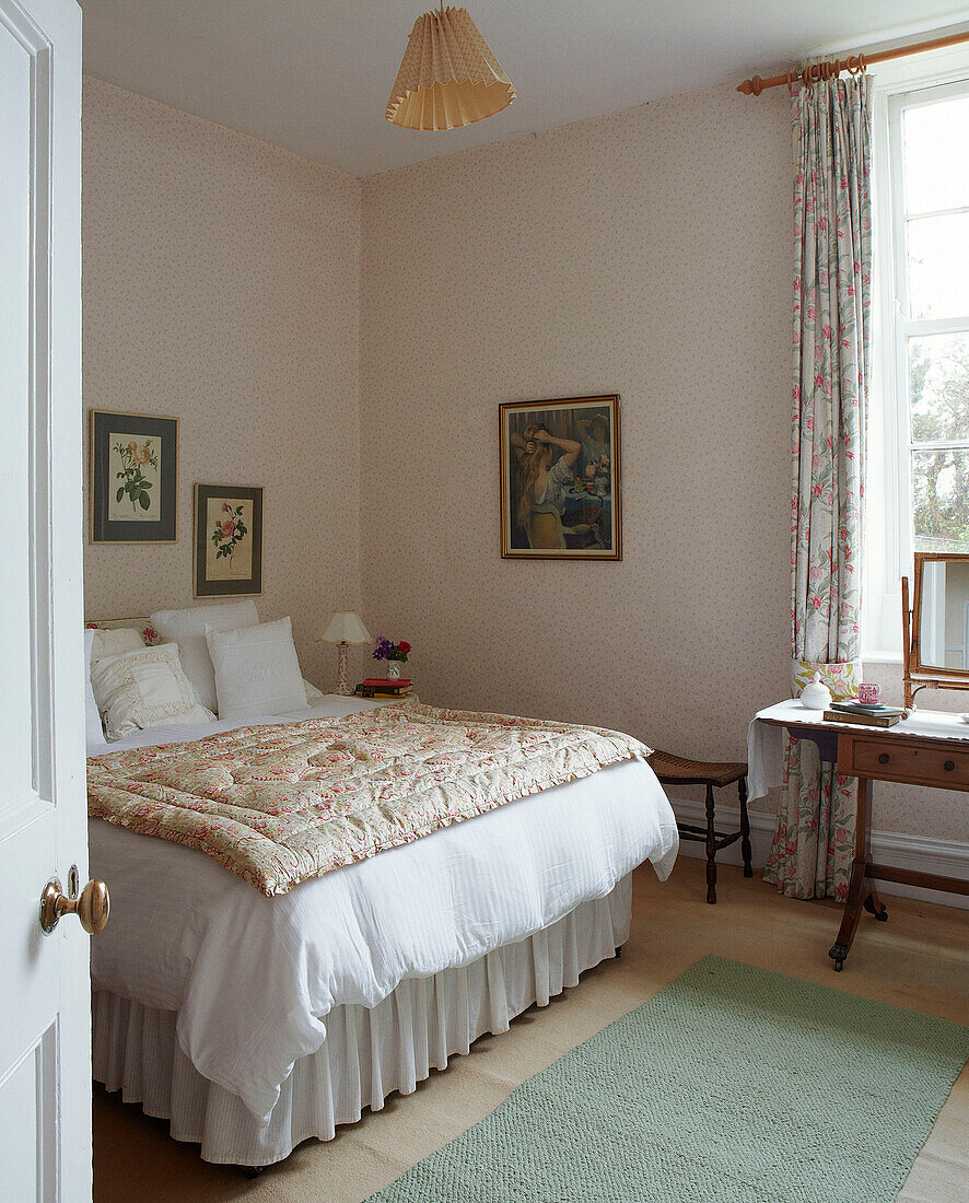 Schminktisch und Bett mit Steppdecke in einem Haus in Syresham, Northamptonshire, UK