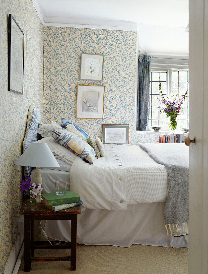 Patchwork pillow on double bed with framed artwork in Syresham home, Northamptonshire, UK
