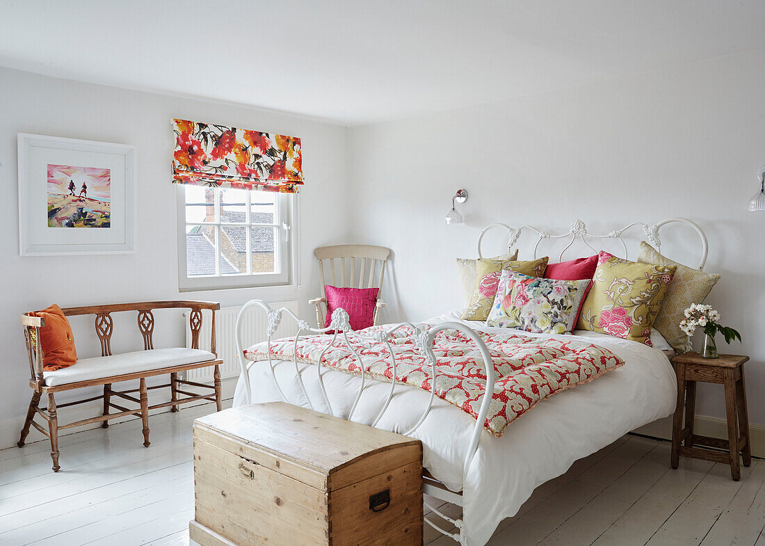 Geblümte Kissen, Steppdecke und Jalousien im Schlafzimmer eines Hauses in Deddington, Oxfordshire, UK