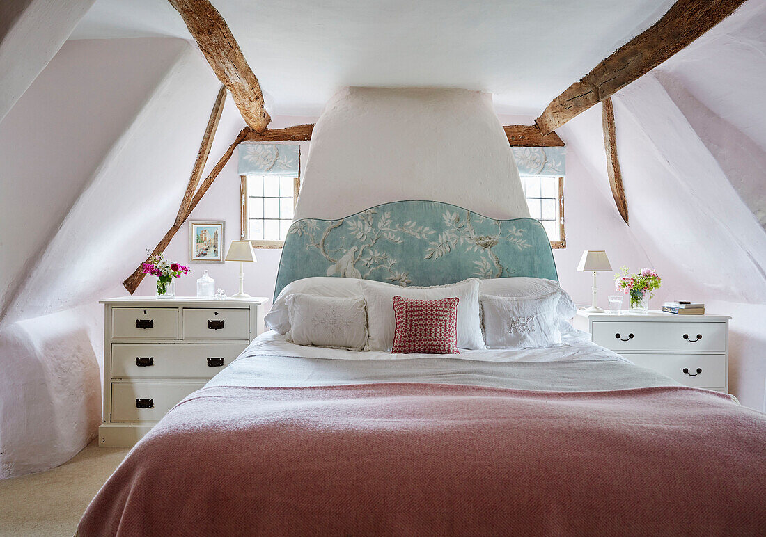 Rosa Decke auf Doppelbett im Dachgeschoss eines Hauses in Berkshire, England, UK