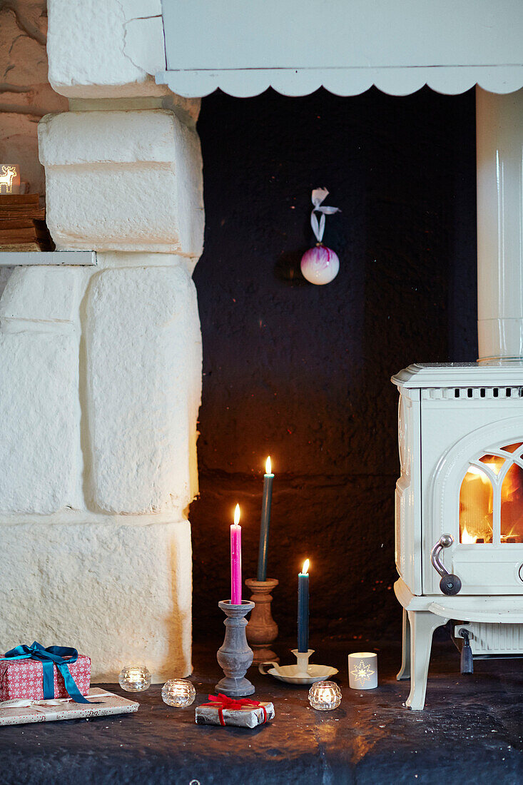 Angezündete Kerzen und eingepackte Geschenke am Kamin in einem bretonischen Landhaus in Frankreich
