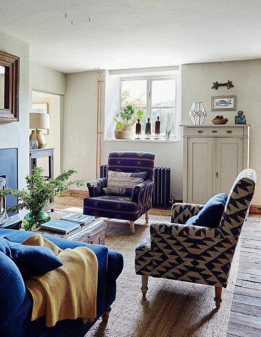 Gepolsterte Sessel mit blauem Sofa in einem Haus in Devon, UK