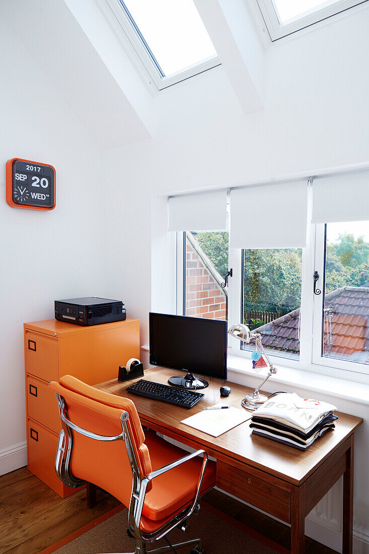 Oranger Stuhl und Aktenschrank mit Schreibtisch am Fenster in einem Haus in Durham, England, UK