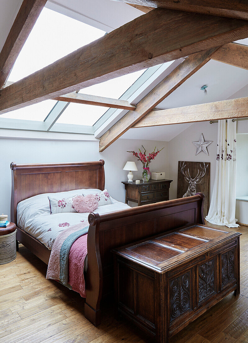 Holzbett unter Dachbalken in einem Bauernhaus in Northumberland, UK