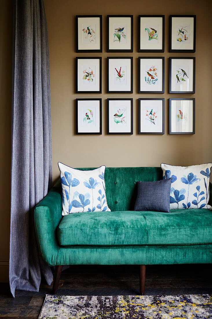 Gerahmte Kunstwerke über einem hellgrünen Sofa in einem Haus in Northumbria, UK