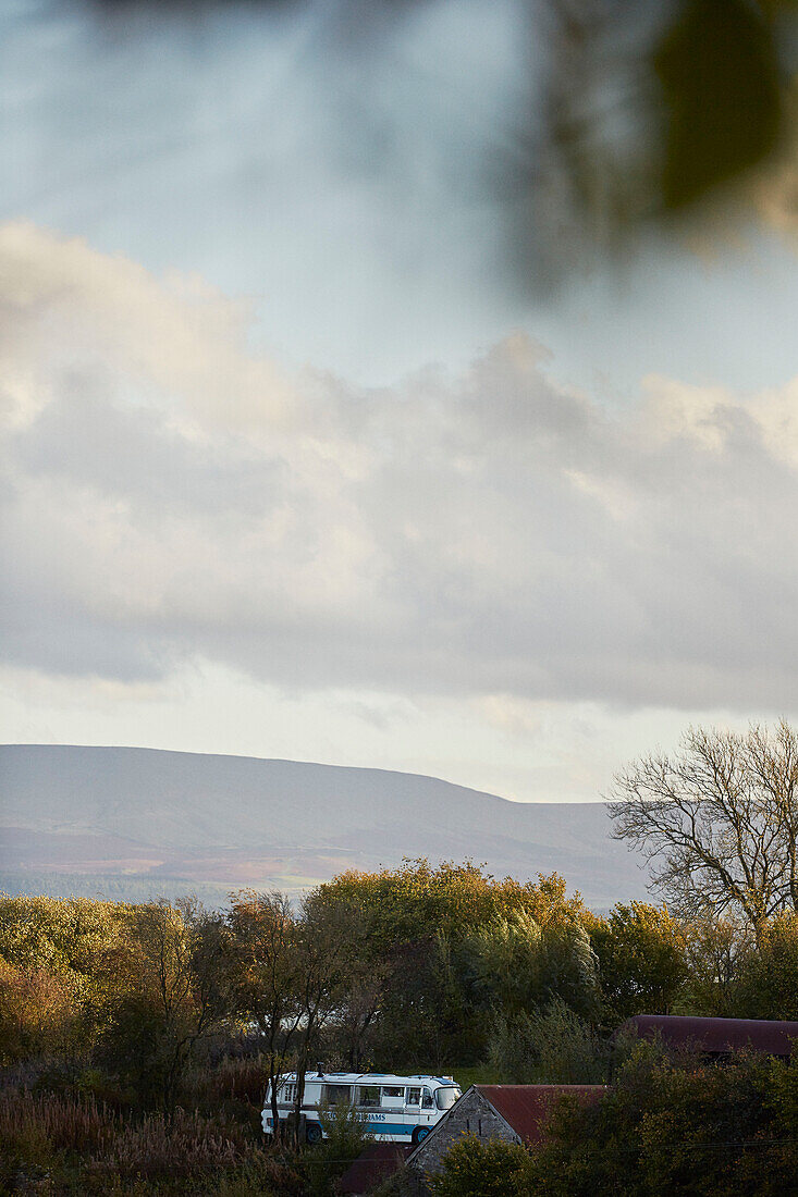 Majestic-Bus in einer Landschaft bei Hay-on-Wye, Wales, UK