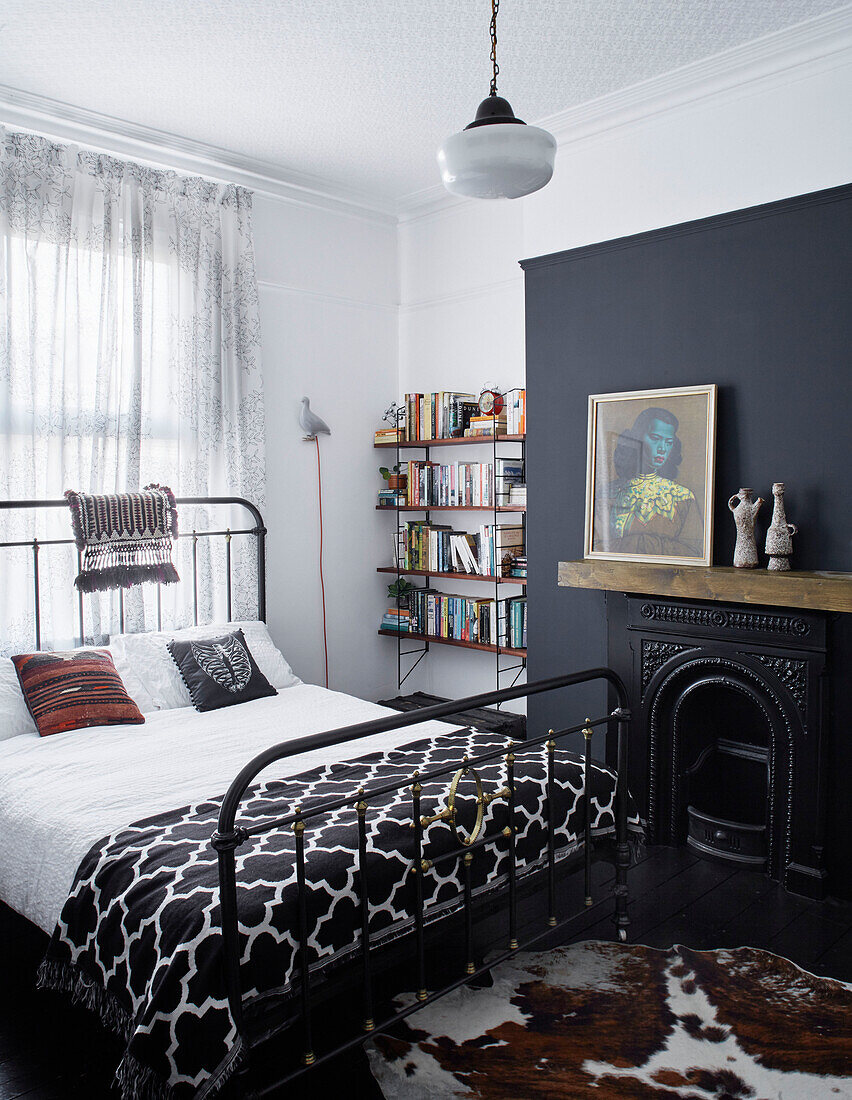 Gardinen und Bett mit Metallrahmen und Bücherregal in einem Haus in Ramsgate, Kent, UK