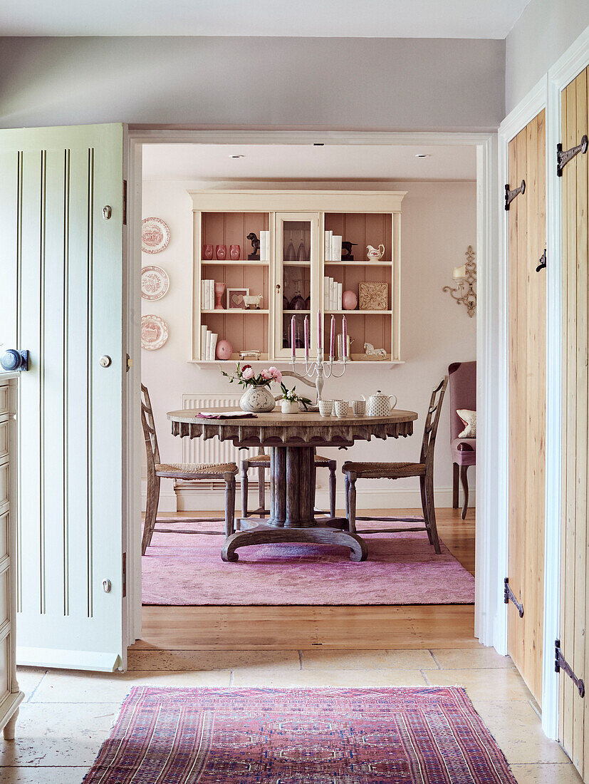 Patterned rugs in hallway with view to dining room in Cotswolds cottage, UK