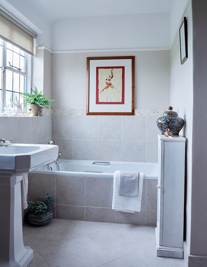 Gefliestes Badezimmer mit Waschbecken und Unterschrank in einem Haus in Devon, UK