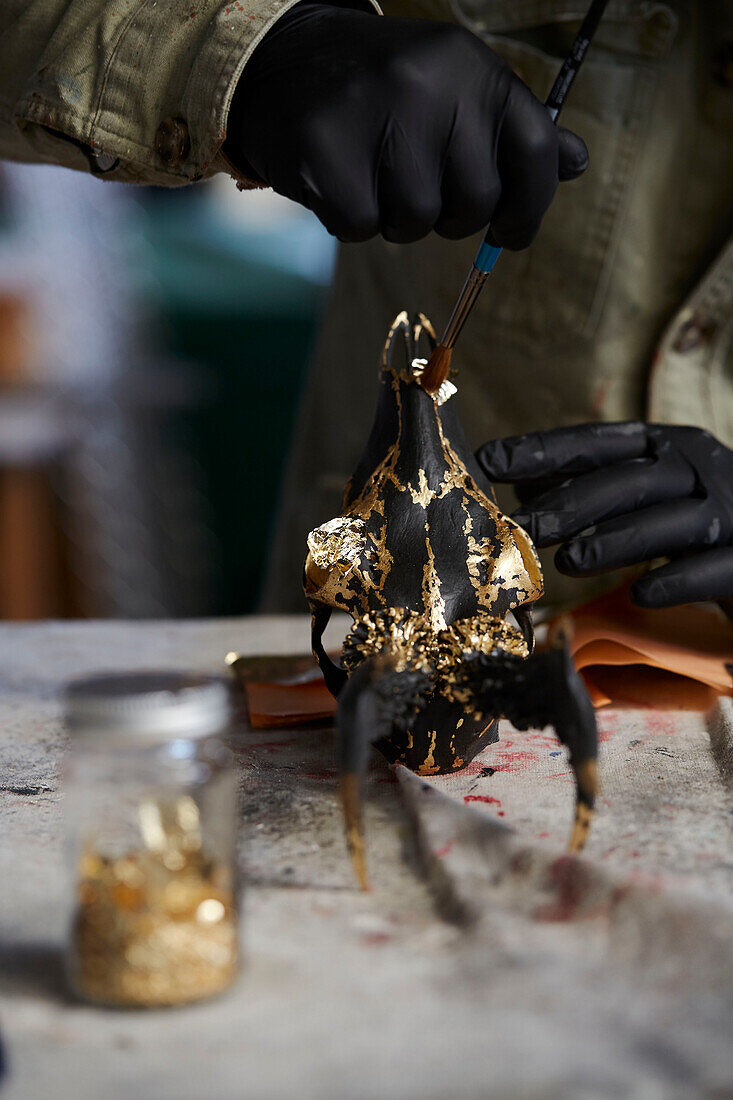 Kunsthandwerker malen Tierschädel in einer Werkstatt in Somerset, UK